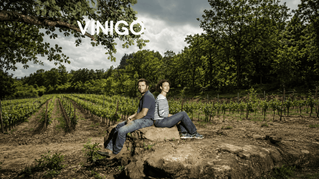 Propriétaires du Domaine SALEL et Renaud sur un rocher avec des vignes derrière